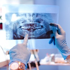 Female patient in striped shirt sitting in dental chair