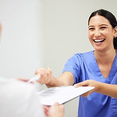 Woman wearing white and smiling with dental implants